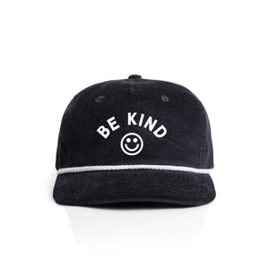Navy blue corduroy cap with 'BE KIND' text and smiley face on a white background