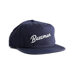 Customizable navy blue cap with 'Bozeman' script text on a white background